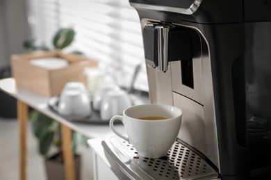 Photo of Modern coffee machine with cup in office. Space for text