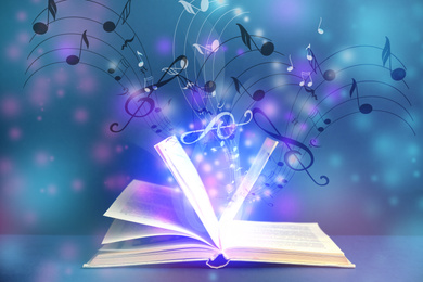 Image of Symphony shining with musical notes from open book on color background 