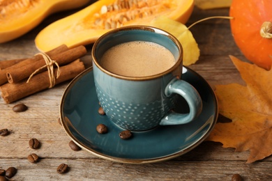 Cup with tasty pumpkin spice latte on wooden table