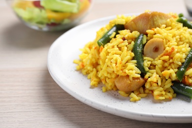 Photo of Delicious pilaf with chicken meat on wooden table, closeup