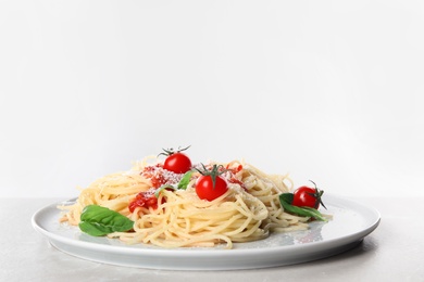 Photo of Tasty pasta on light grey marble table against white background