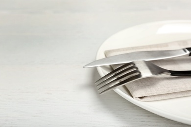 Photo of Plate with fork and knife on table, closeup. New setting