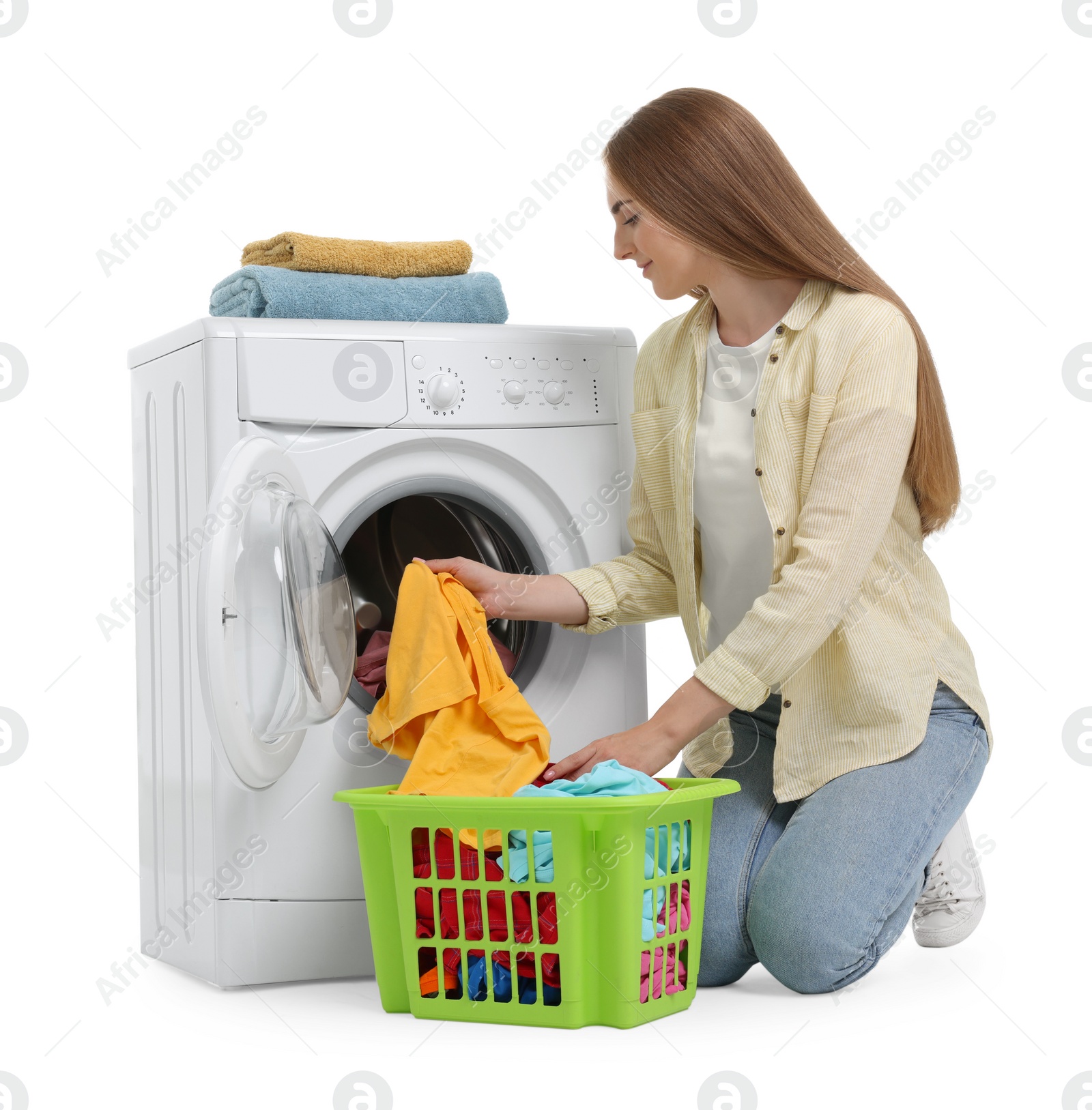 Photo of Beautiful young woman taking laundry out of washing machine on white background