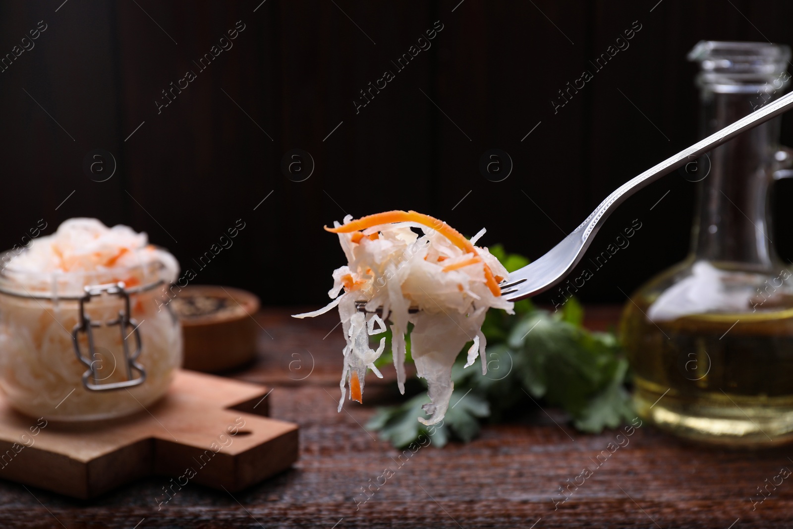 Photo of Fork with tasty sauerkraut above wooden table