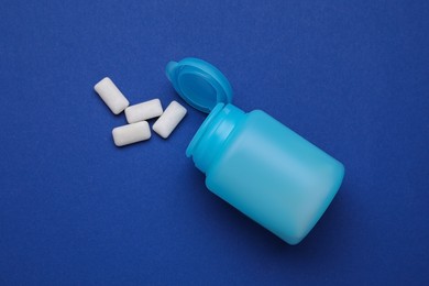 Photo of Jar with chewing gums on blue background, flat lay