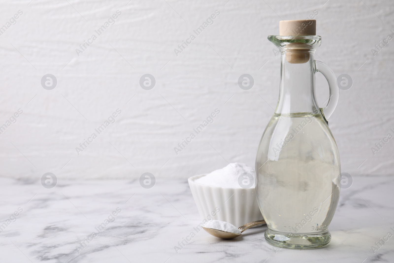 Photo of Vinegar and baking soda on white marble table, space for text