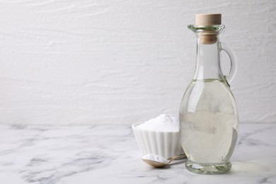 Photo of Vinegar and baking soda on white marble table, space for text