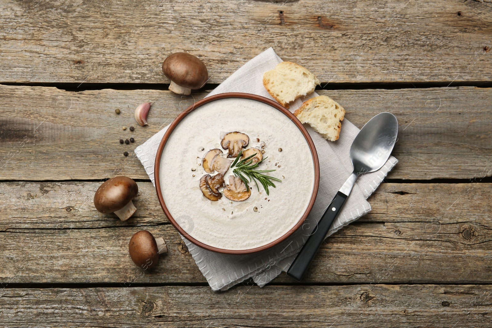 Photo of Fresh homemade mushroom soup served on wooden table, flat lay