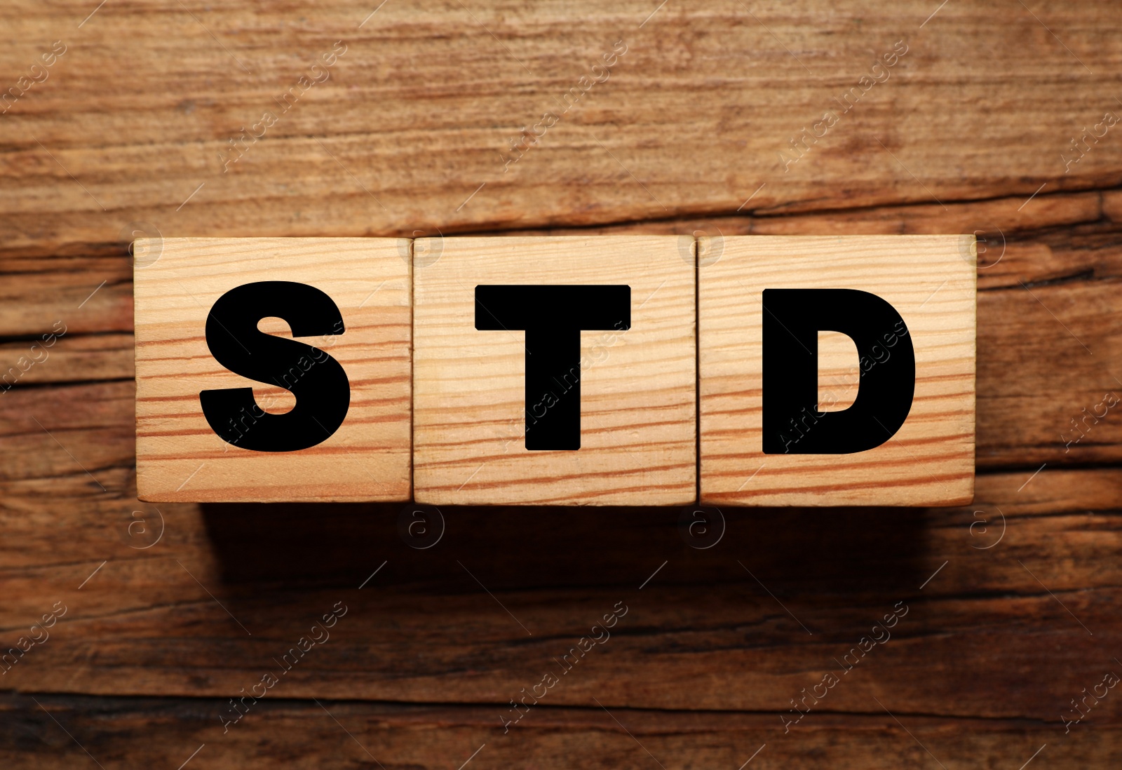 Photo of Wooden cubes with letters STD (sexually transmitted diseases) on table, flat lay