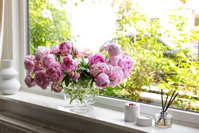 Beautiful pink peonies in vase on window sill. Interior design