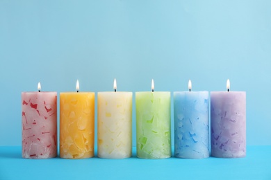 Photo of Alight scented wax candles on color background