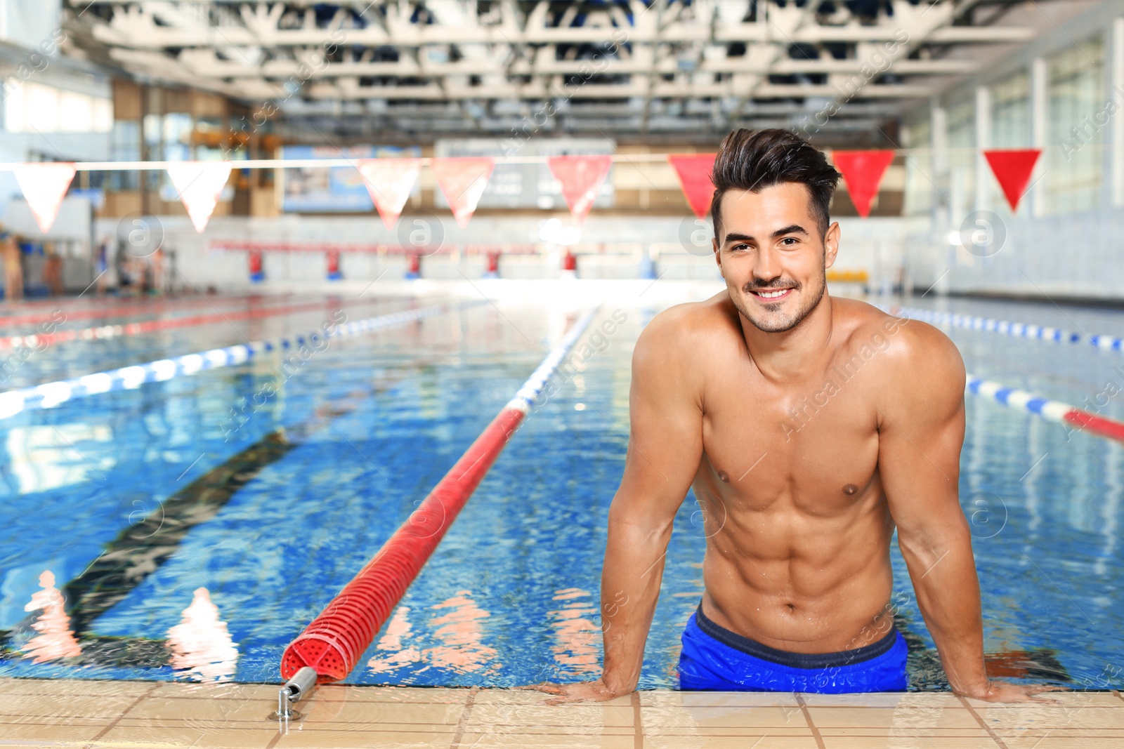 Photo of Young athletic man in swimming pool indoors