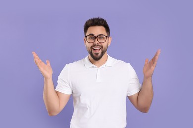 Photo of Excited man wearing glasses on violet background