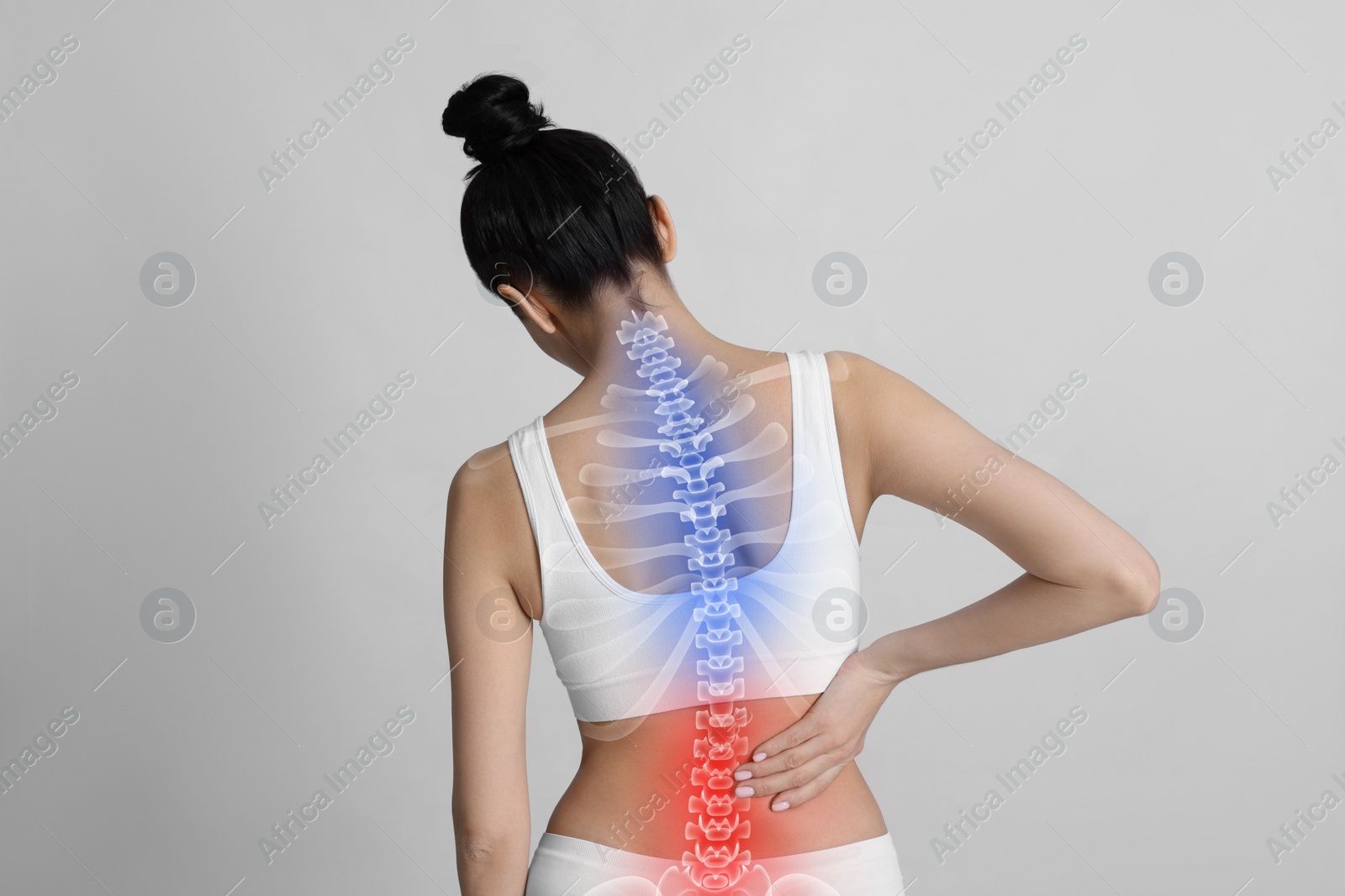 Image of Woman suffering from pain in back on light background