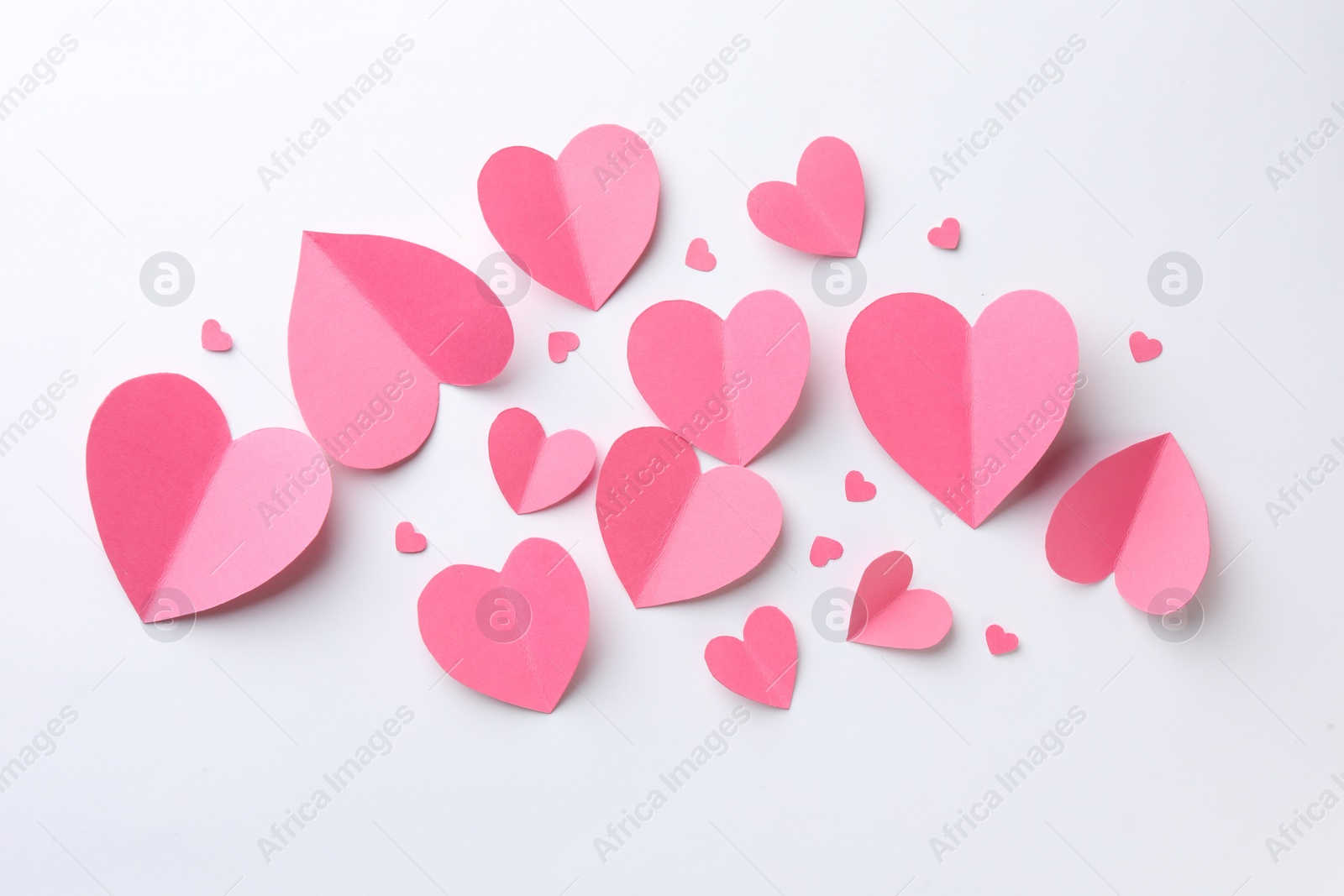 Photo of Pink paper hearts on white background, flat lay