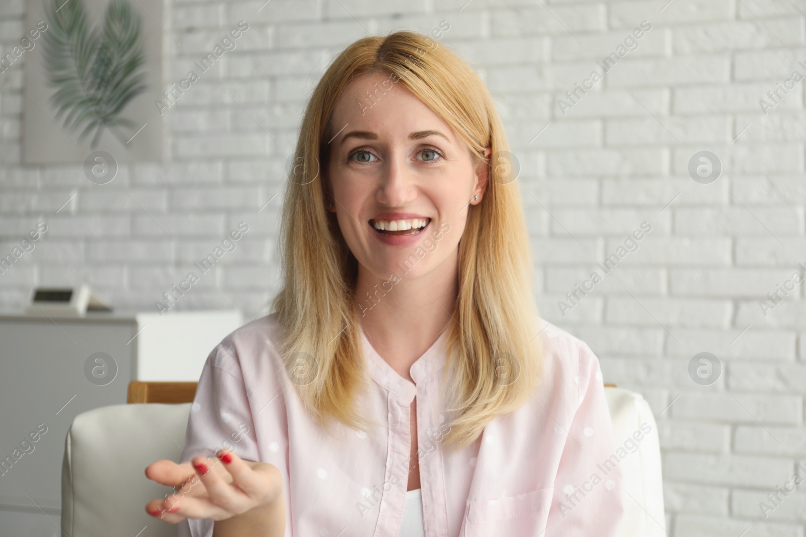 Photo of Woman talking to her coworkers through video conference indoors, view from webcam