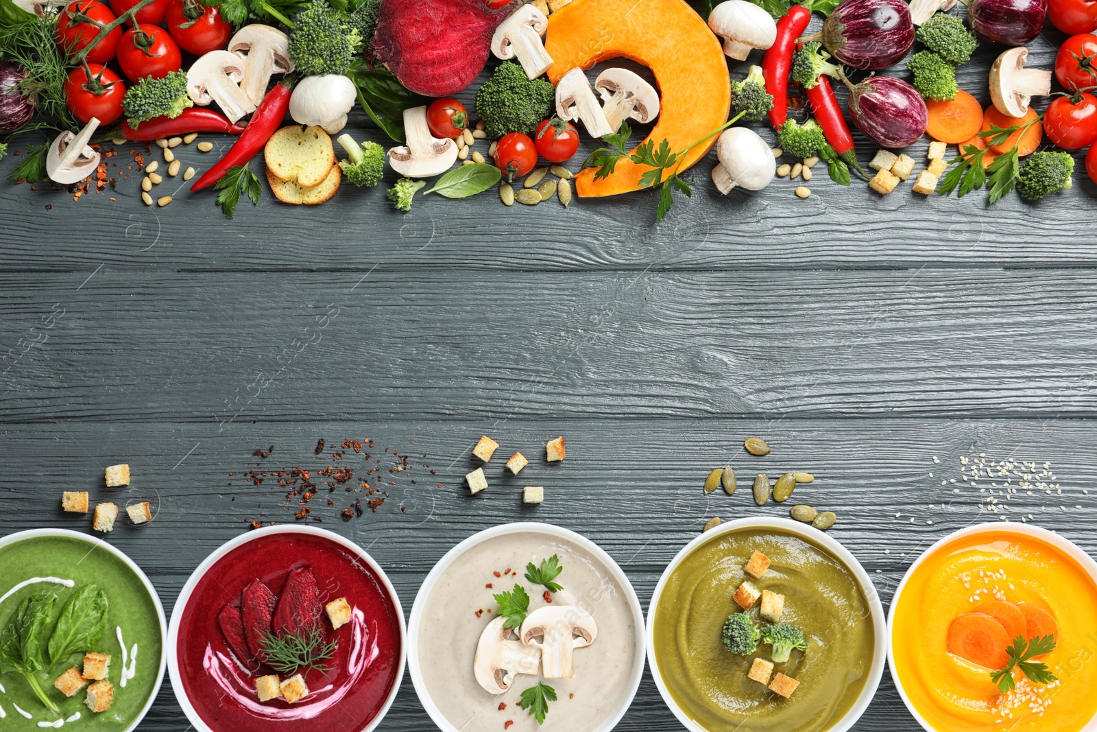 Photo of Various cream soups, ingredients and space for text on wooden background, flat lay. Healthy food