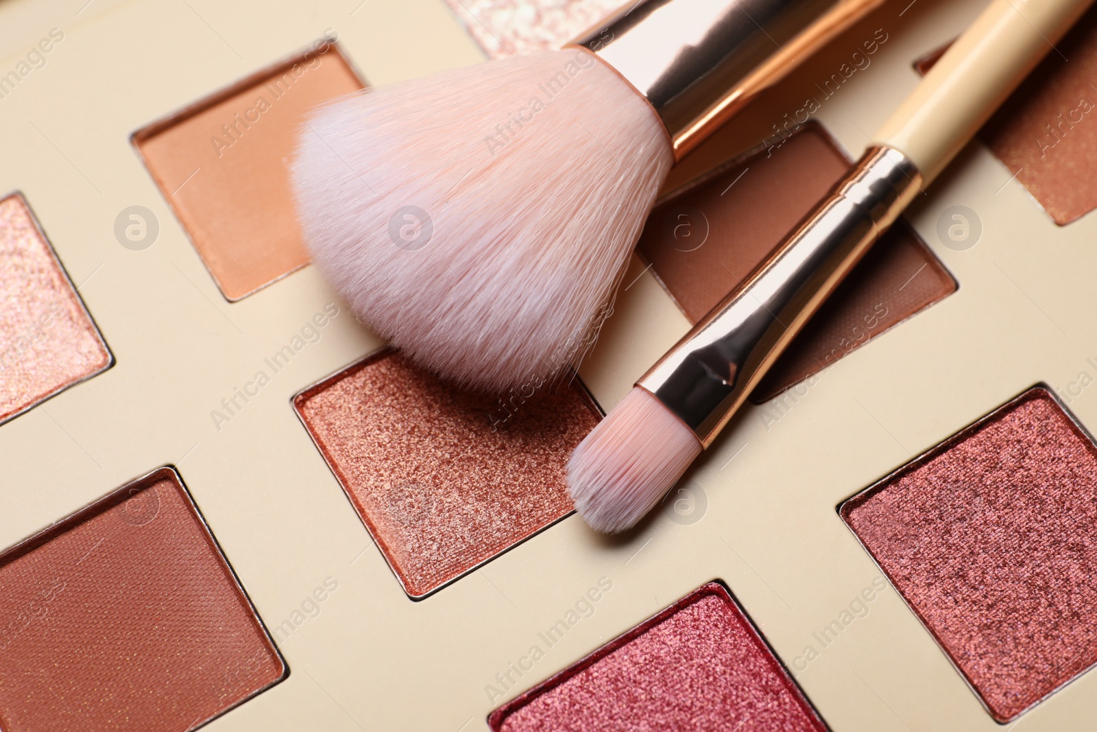 Photo of Beautiful eye shadow palette and brushes as background, closeup