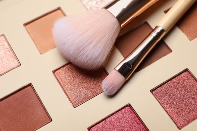Beautiful eye shadow palette and brushes as background, closeup