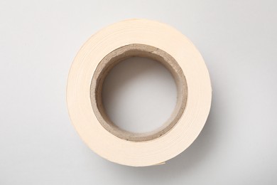 Photo of Roll of adhesive tape on light background, top view
