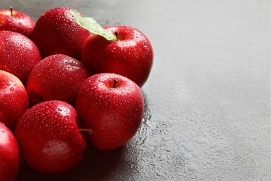 Fresh red apples with drops of water on table