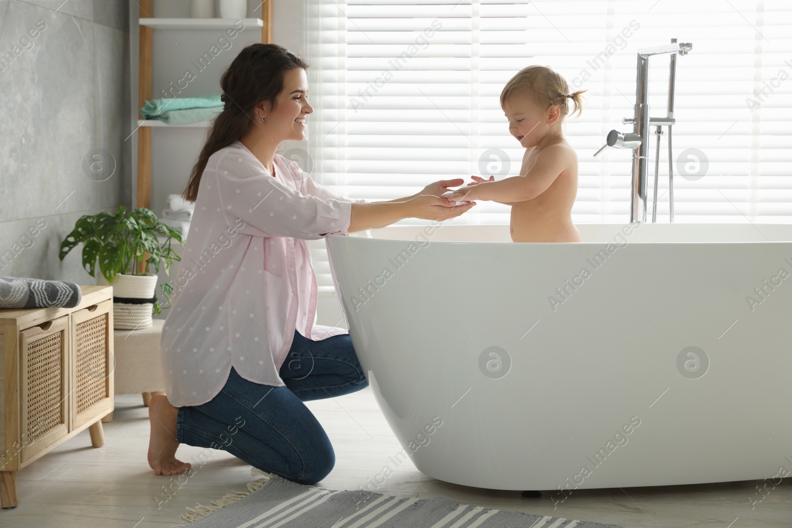 Photo of Mother with her little daughter in bathroom