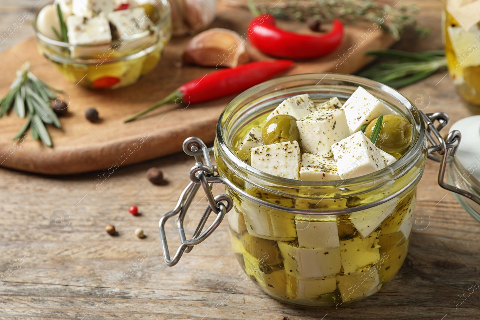 Photo of Composition with pickled feta cheese in jar on wooden table, space for text