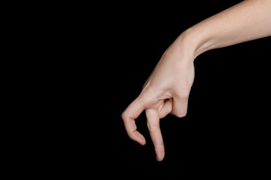 Woman imitating walk with hand on black background, closeup. Finger gesture