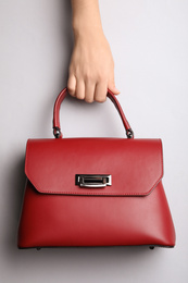 Photo of Woman holding small bag on light grey background, top view