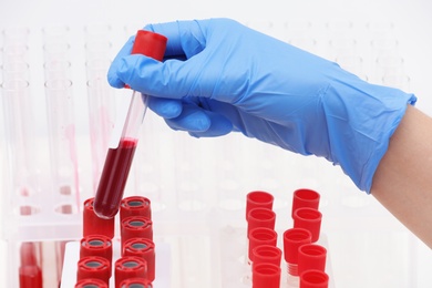 Scientist working with blood samples in test tubes at table