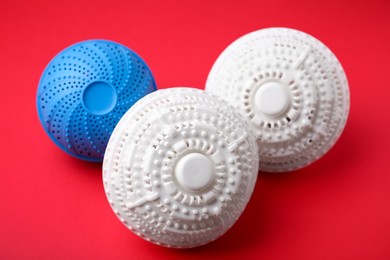 Photo of Dryer balls for washing machine on red background. Laundry detergent substitute