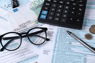 Photo of Tax accounting. Calculator, money, glasses and stationery on documents, closeup