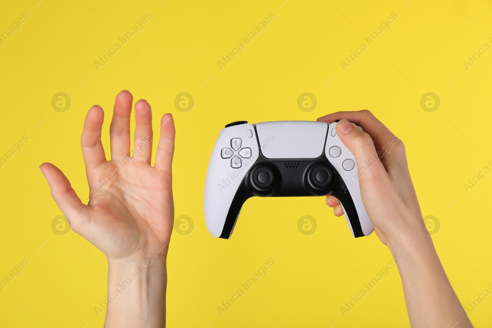Photo of Woman with game controller on yellow background, closeup