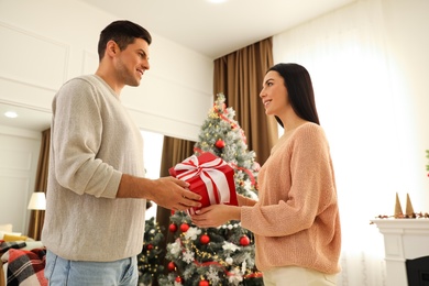 Happy couple with Christmas gift at home