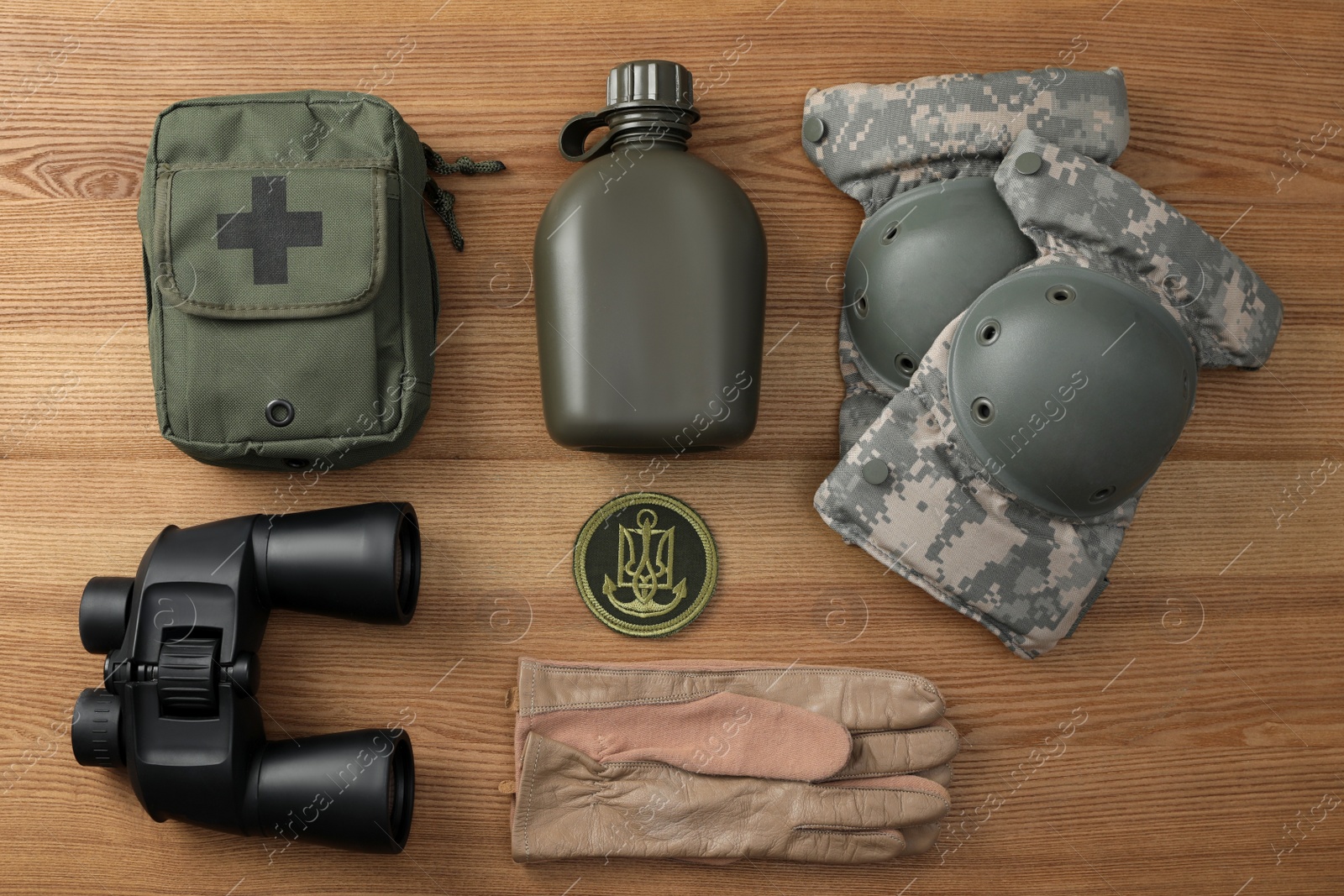 Photo of MYKOLAIV, UKRAINE - SEPTEMBER 26, 2020: Tactical gear and Ukrainian army patch on wooden table, flat lay