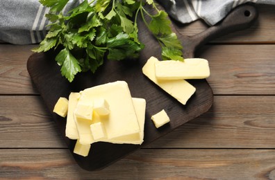 Tasty butter and parsley on wooden table, top view