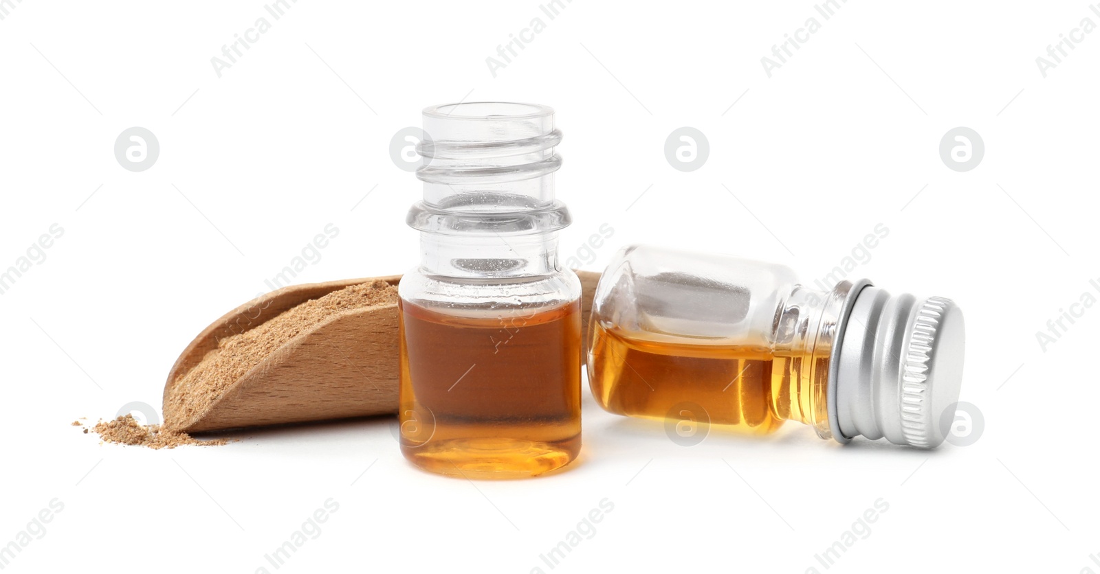 Photo of Bottles of cinnamon oil and scoop with powder on white background