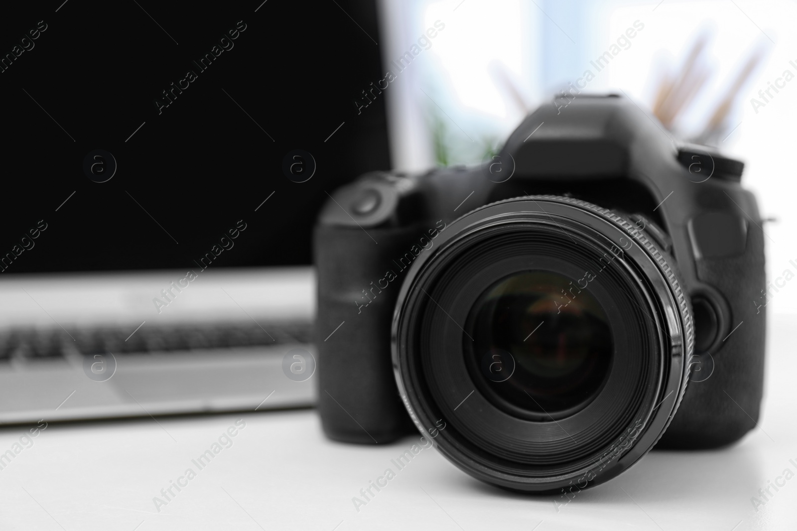 Photo of Digital camera on white table. Equipment for professional photographer