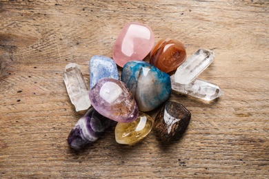 Photo of Flat lay composition with different gemstones on wooden table