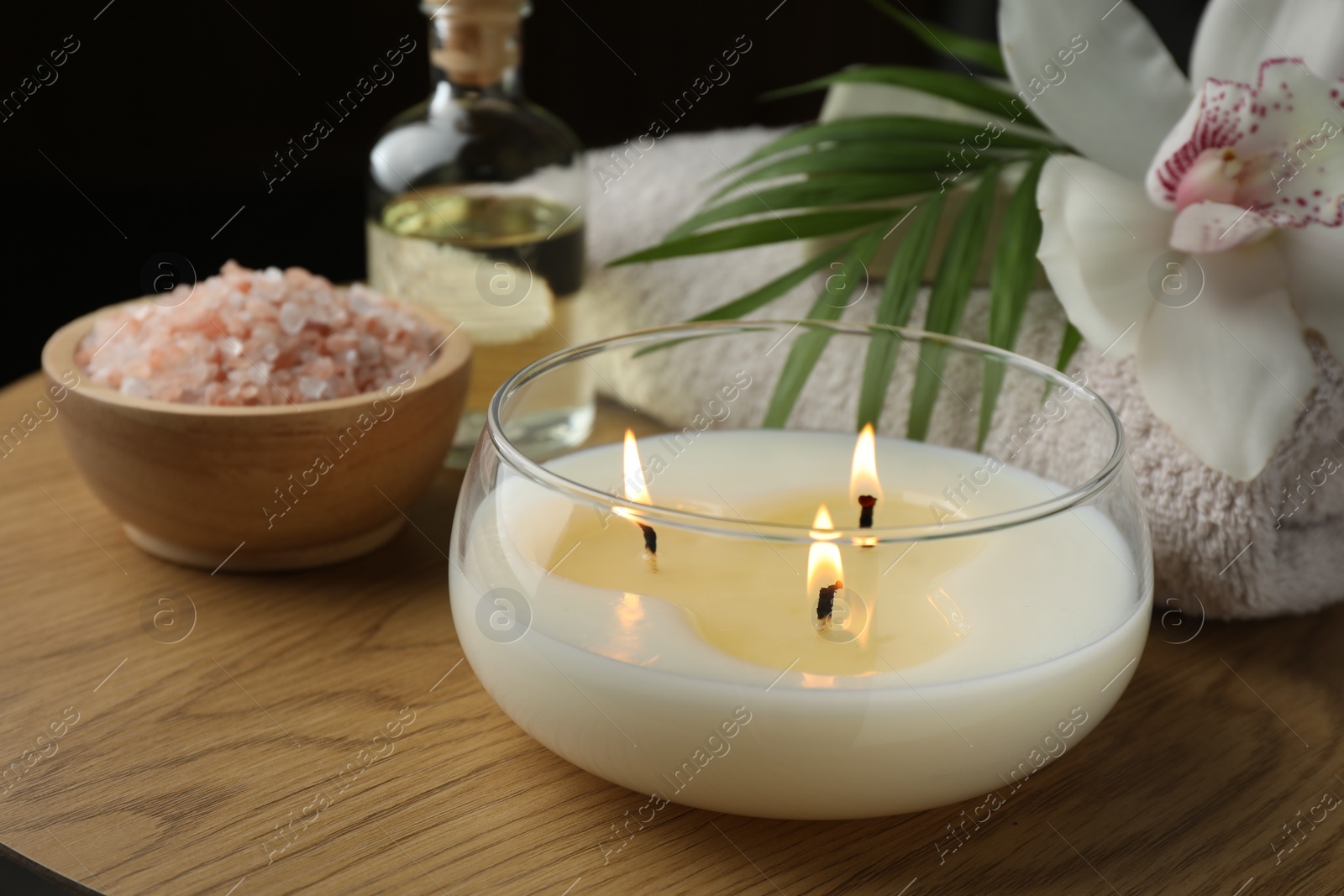 Photo of Composition with different spa products and burning candle on wooden table