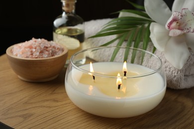 Photo of Composition with different spa products and burning candle on wooden table