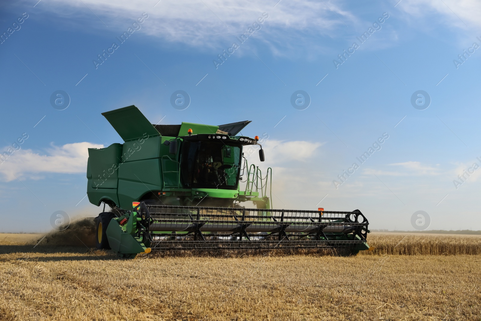 Photo of Modern combine harvester working in agricultural field