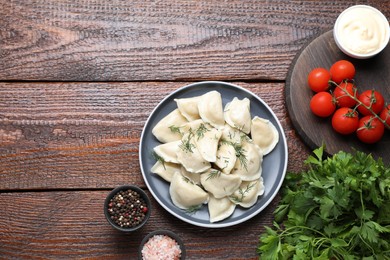 Photo of Delicious dumplings served on wooden table, flat lay. Space for text