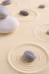 Photo of Zen garden stones on sand with pattern, closeup