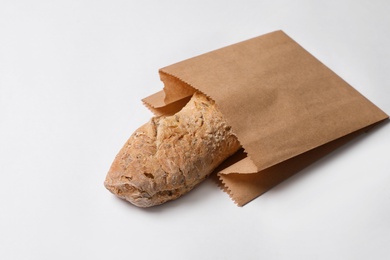 Photo of Paper bag with bread on white background