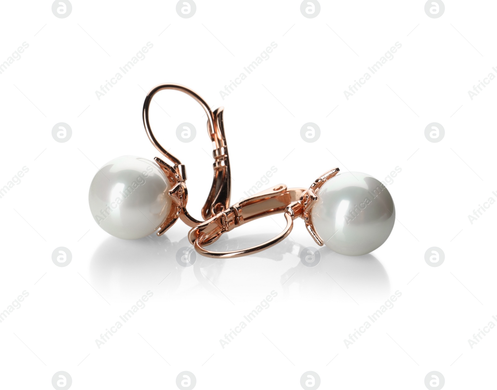 Photo of Elegant golden earrings with pearls on white background