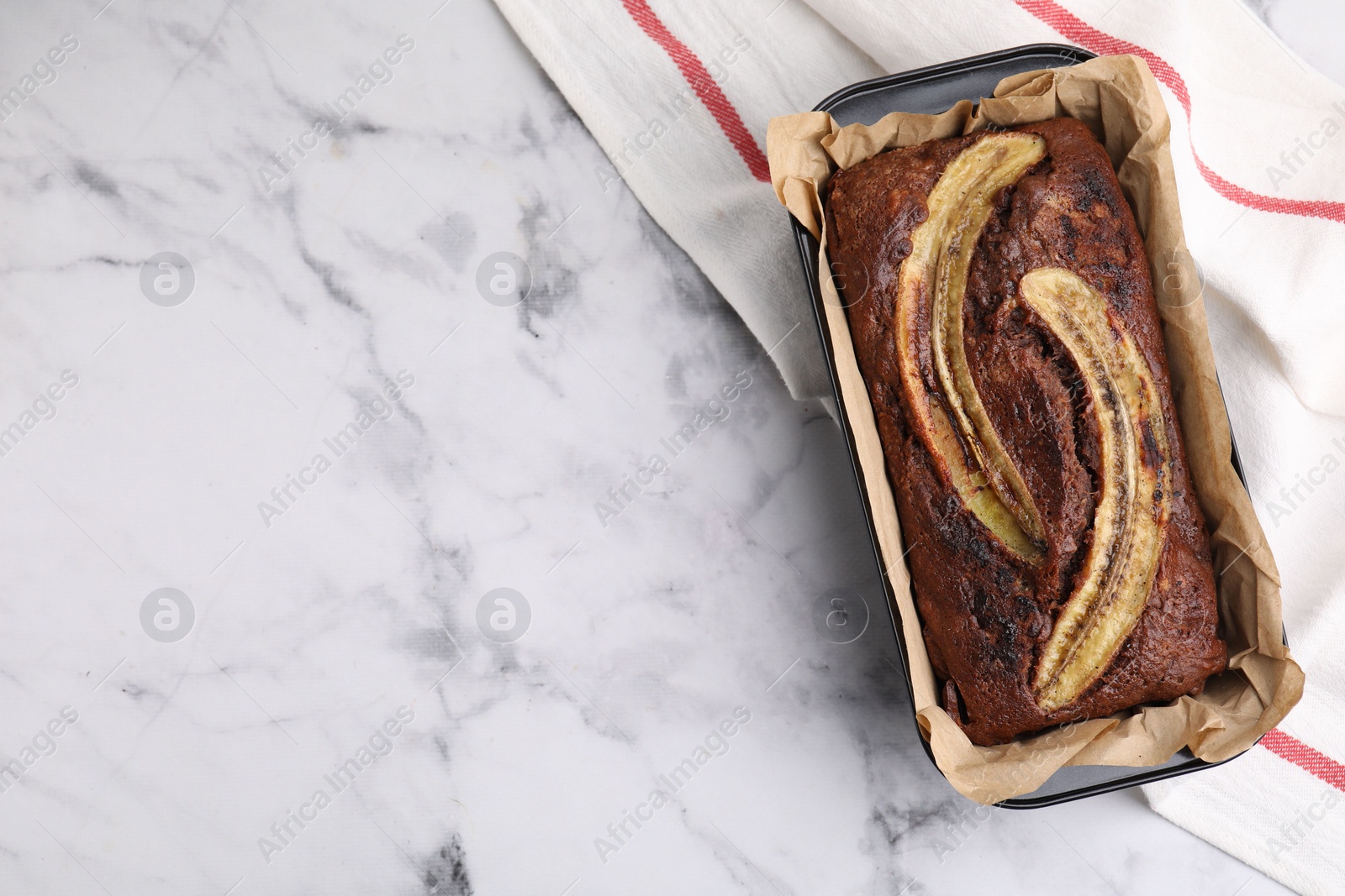 Photo of Delicious banana bread on white marble table, top view. Space for text