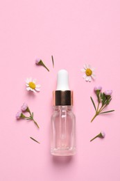 Photo of Bottle of cosmetic serum and beautiful flowers on pink background, flat lay