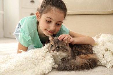 Photo of Cute little girl with cat lying on carpet at home. First pet