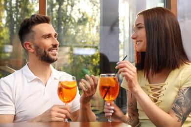 Happy couple with Aperol spritz cocktails outdoors